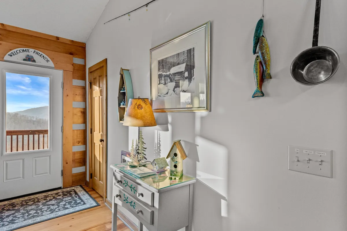 This image showcases a welcoming entryway with a 'welcome' sign, lamp, decorative fish, and entry table. The soft lighting and cozy décor immediately impart a sense of hospitality and comfort to arriving guests, setting the tone for a hassle-free stay.
